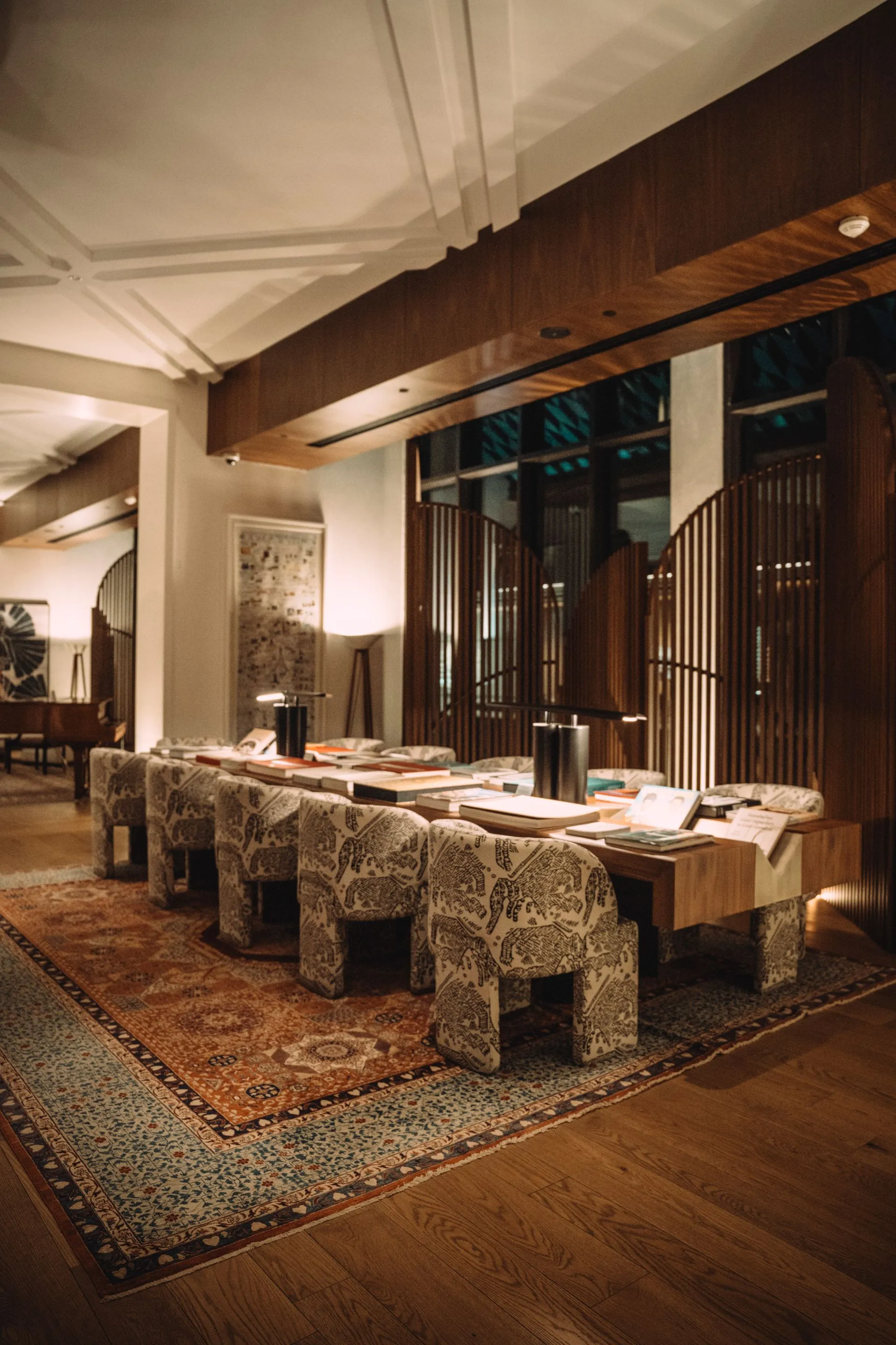 Warm timber-and-brass residence lounge with silk rugs and soft lighting